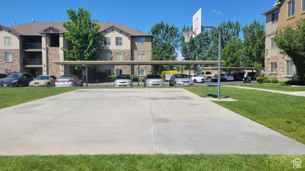 View of property's community with covered parking and a yard