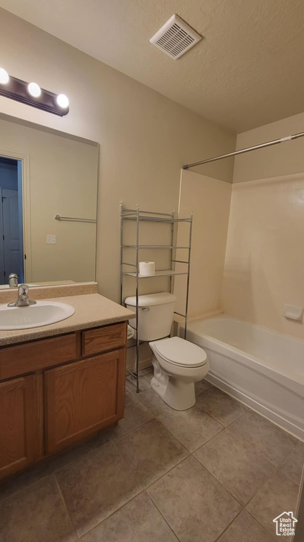 Bathroom featuring tile patterned floors, vanity, toilet, and bathtub / shower combination