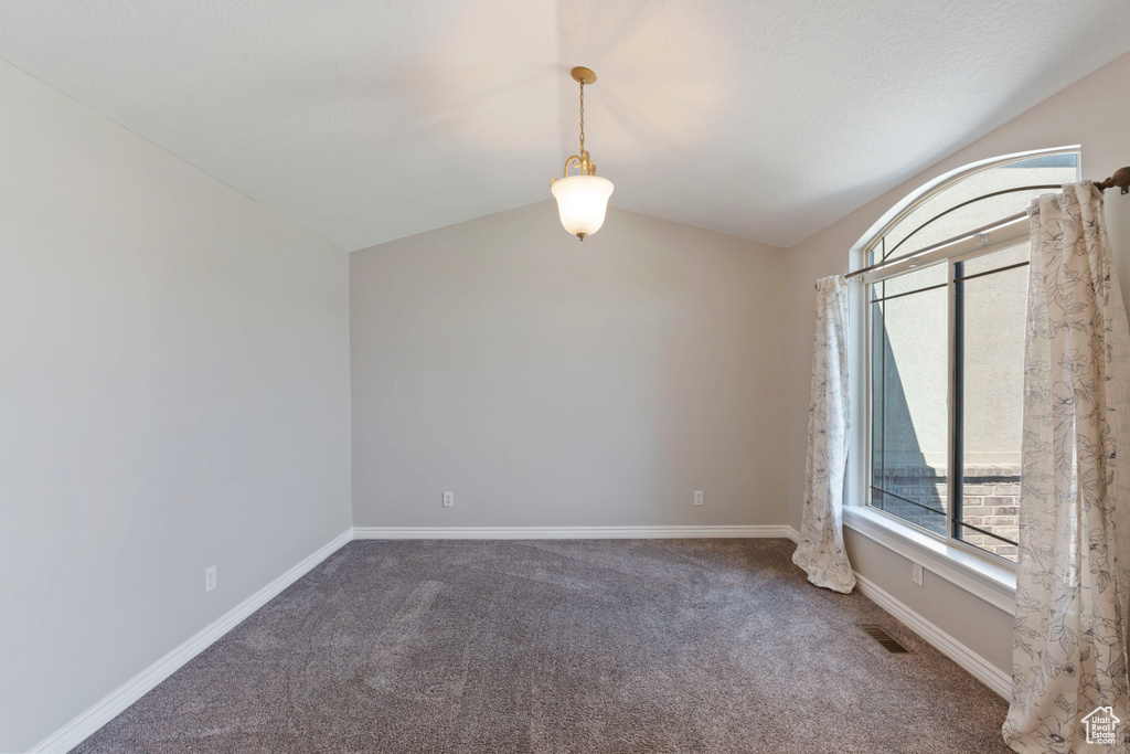 Unfurnished room with carpet flooring, lofted ceiling, and baseboards