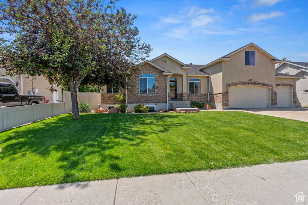 View of front of property featuring stucco siding, an attached garage, and concrete driveway