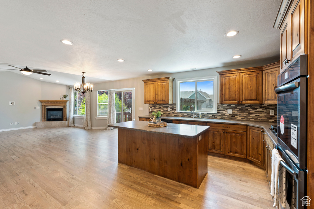 Kitchen featuring a center island, tasteful backsplash, plenty of natural light, brown cabinetry, and recessed lighting