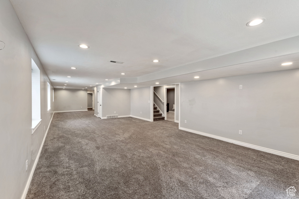 Below grade area with recessed lighting, carpet floors, stairs, and baseboards