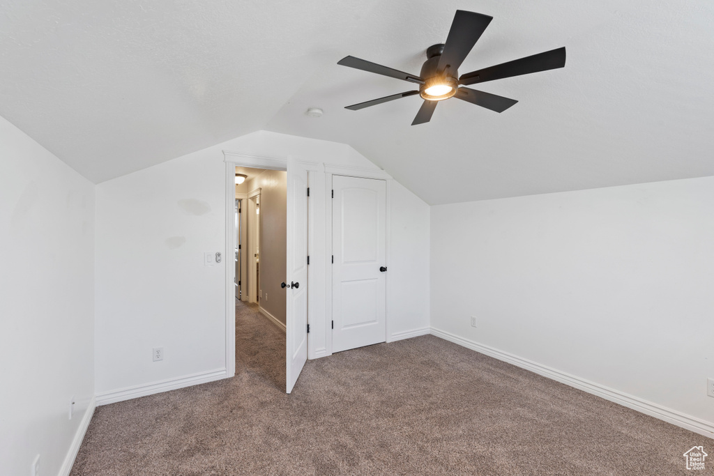 Bonus room featuring carpet floors, vaulted ceiling, a ceiling fan, and baseboards
