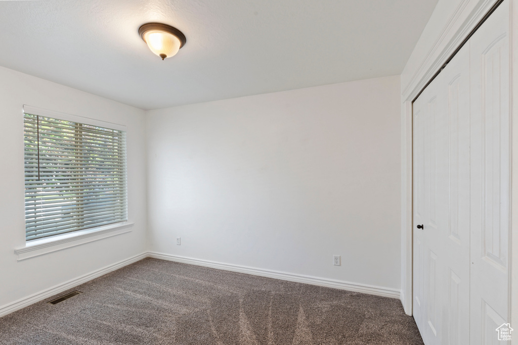 Carpeted spare room with baseboards
