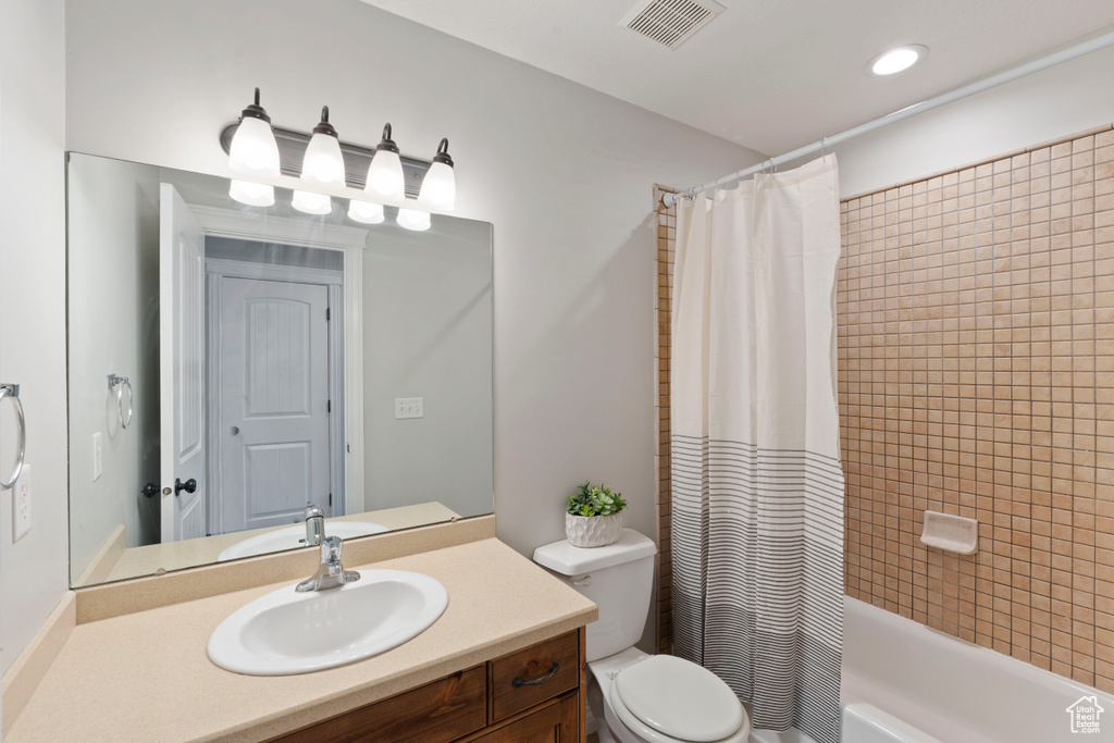 Full bathroom with vanity, toilet, and shower / bath combo