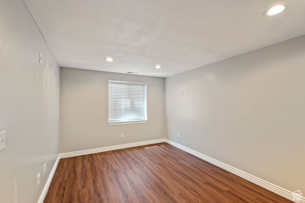 Empty room with baseboards, wood finished floors, and recessed lighting