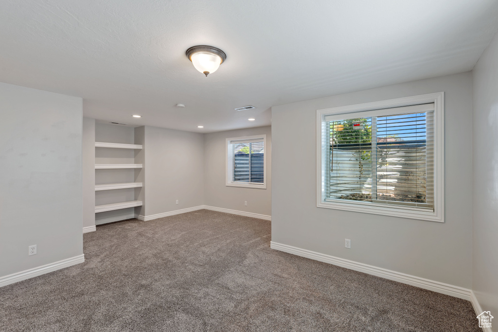 Empty room featuring carpet, baseboards, and recessed lighting