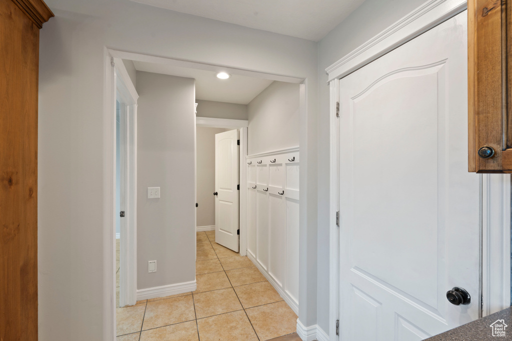 Corridor featuring light tile patterned floors and baseboards