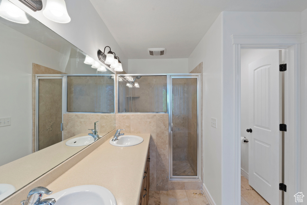 Full bathroom with double vanity and a stall shower