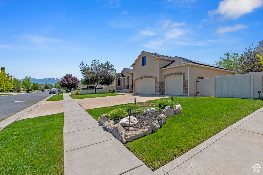 View of property exterior with stucco siding, concrete driveway, an attached garage, and a mountain view