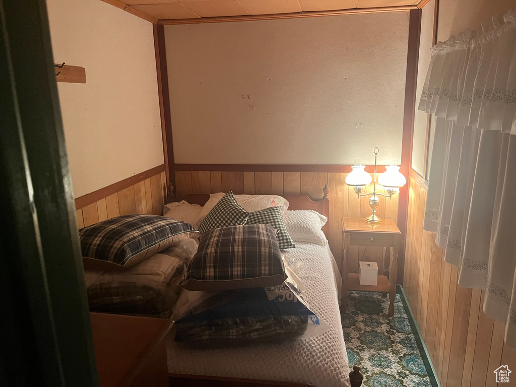 Bedroom featuring wooden walls and a wainscoted wall