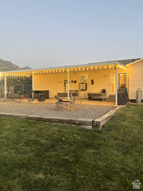 Back of house featuring a patio, a yard, and a mountain view