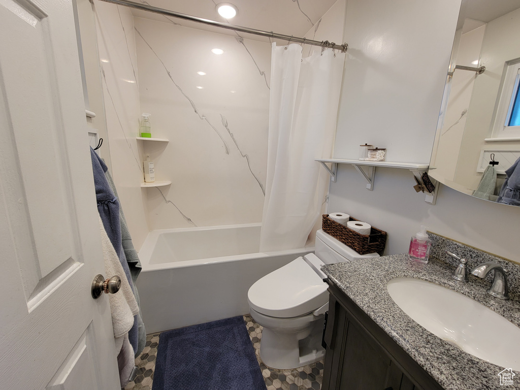 Full bath featuring shower / bath combo, vanity, and toilet