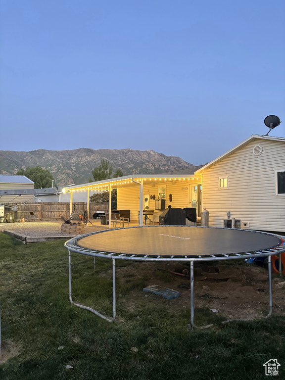 View of yard with a trampoline and a mountain view