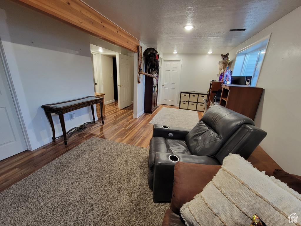 Living area featuring light wood finished floors and a textured ceiling