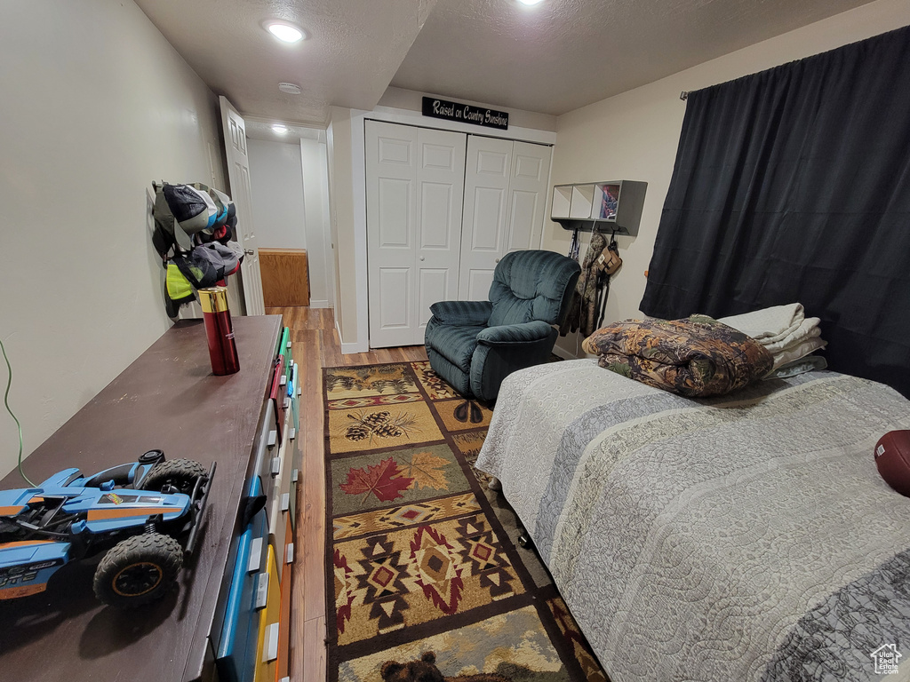 Bedroom featuring wood finished floors and a closet