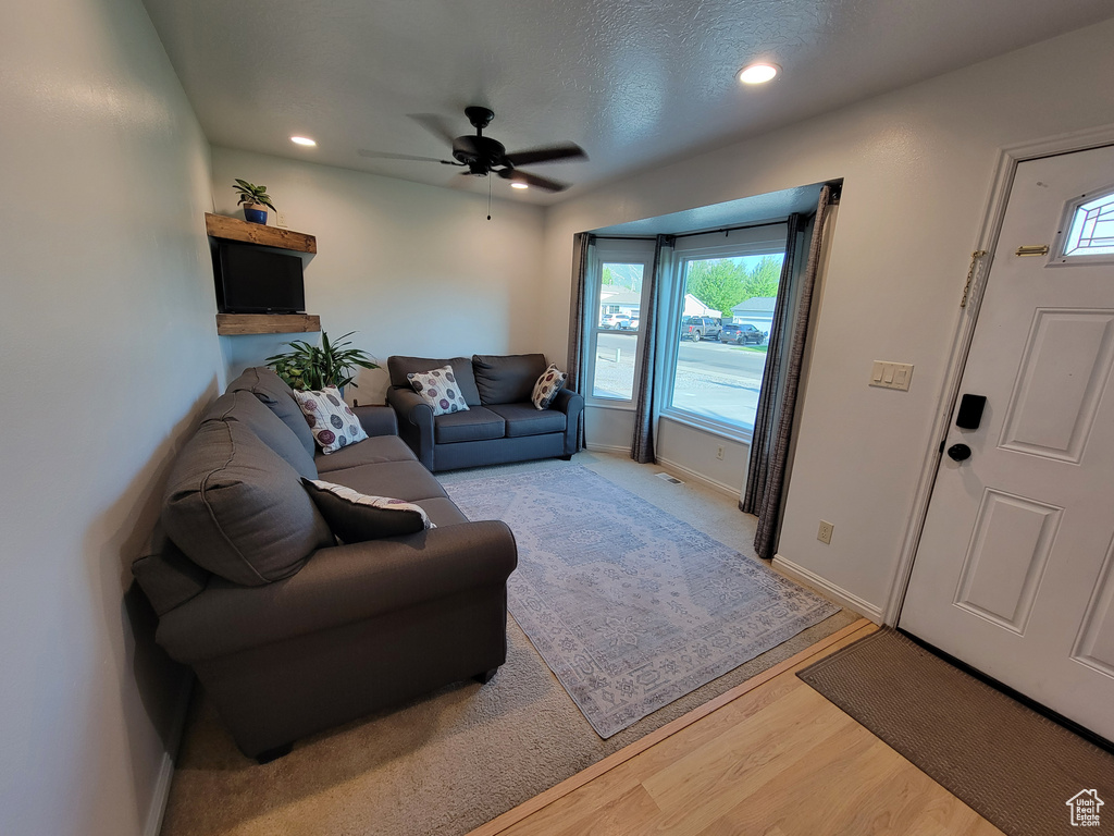Living room featuring plenty of natural light, ceiling fan, light wood finished floors, baseboards, and recessed lighting