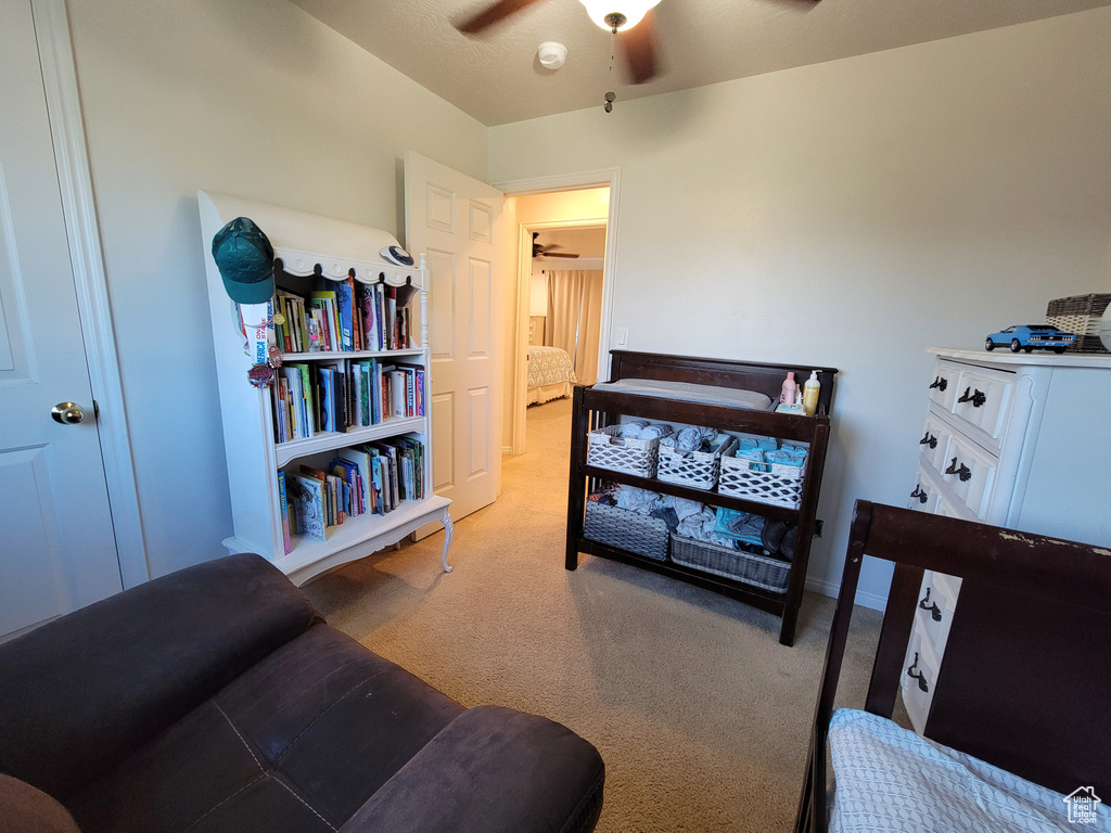 Carpeted bedroom with a ceiling fan and baseboards