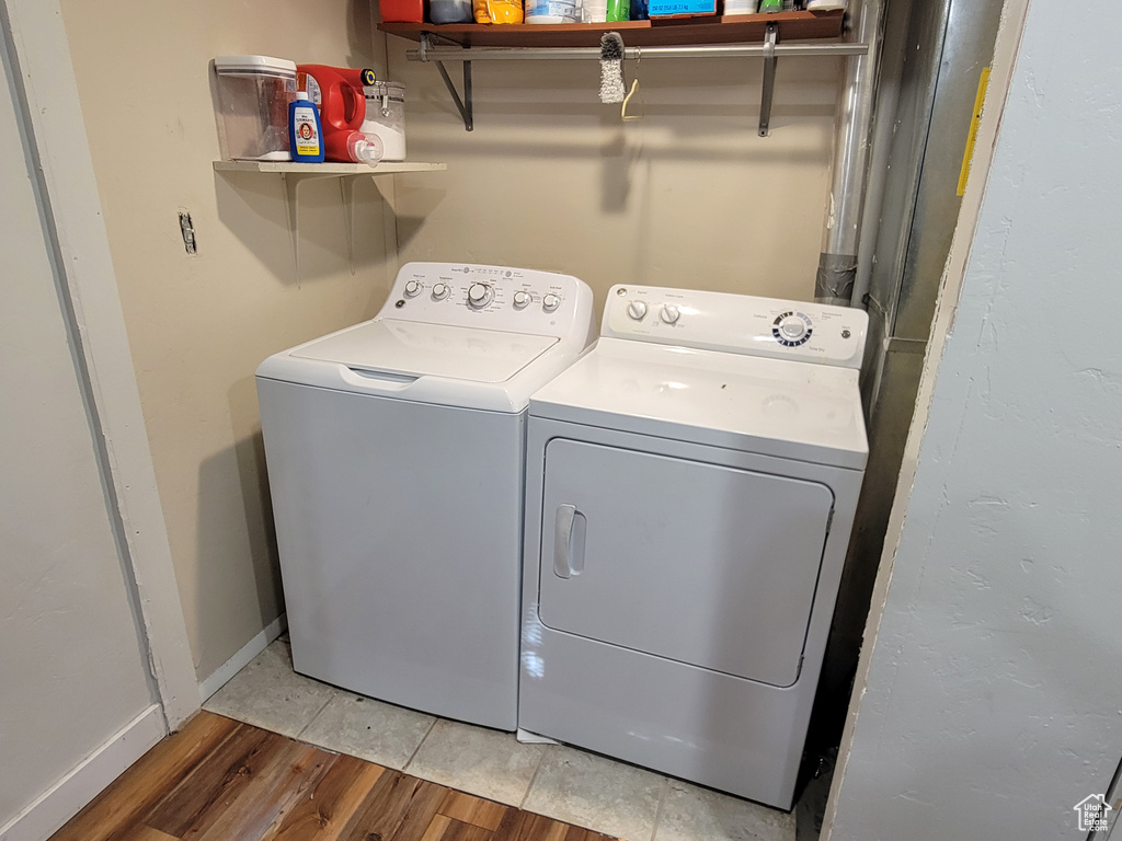 Laundry room featuring washing machine and dryer and light wood-type flooring