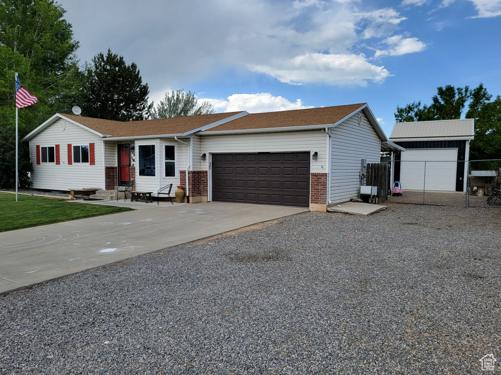 Ranch-style home with an attached garage, driveway, and brick siding