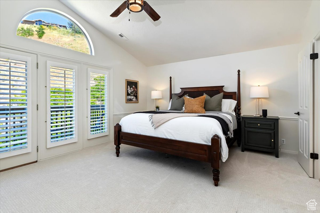 Bedroom featuring light carpet, access to outside, high vaulted ceiling, and a ceiling fan