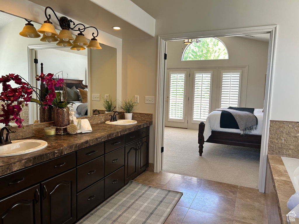 Ensuite bathroom featuring double vanity, a bathtub, and tile patterned floors