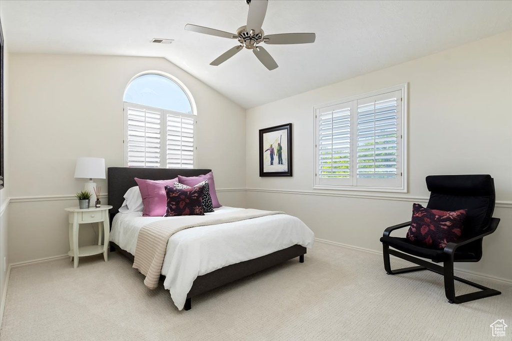 Bedroom featuring lofted ceiling, light colored carpet, baseboards, and ceiling fan