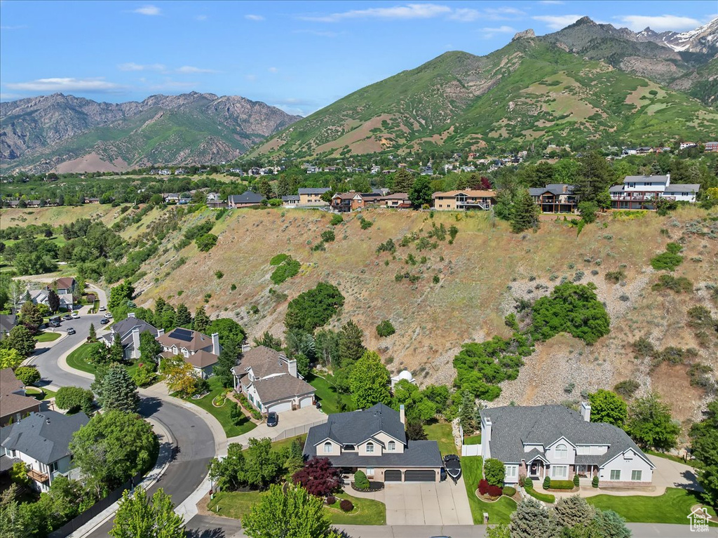 Aerial view of property and surrounding area featuring a mountain backdrop and nearby suburban area