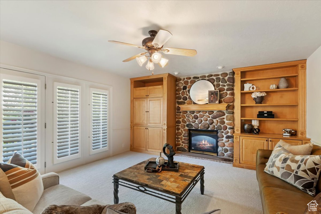 Carpeted living room with ceiling fan and a fireplace