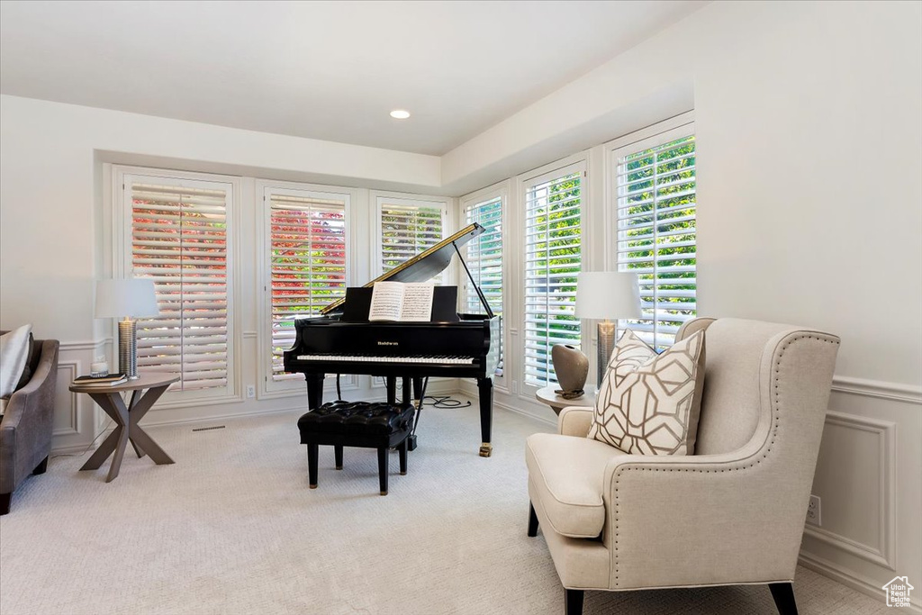 Sitting room with carpet floors, a wainscoted wall, and a decorative wall