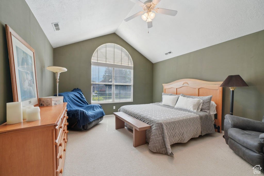 Carpeted bedroom with vaulted ceiling and a ceiling fan