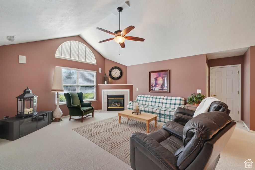 Living area featuring carpet floors, a ceiling fan, lofted ceiling, and plenty of natural light