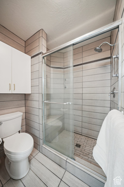 Full bath with a shower stall and toilet