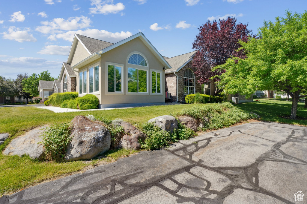 Rear view of house featuring a lawn and stucco siding