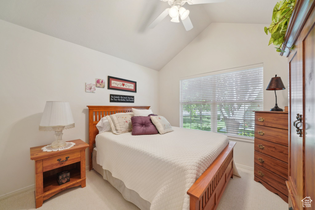 Bedroom with light colored carpet, lofted ceiling, ceiling fan, and baseboards