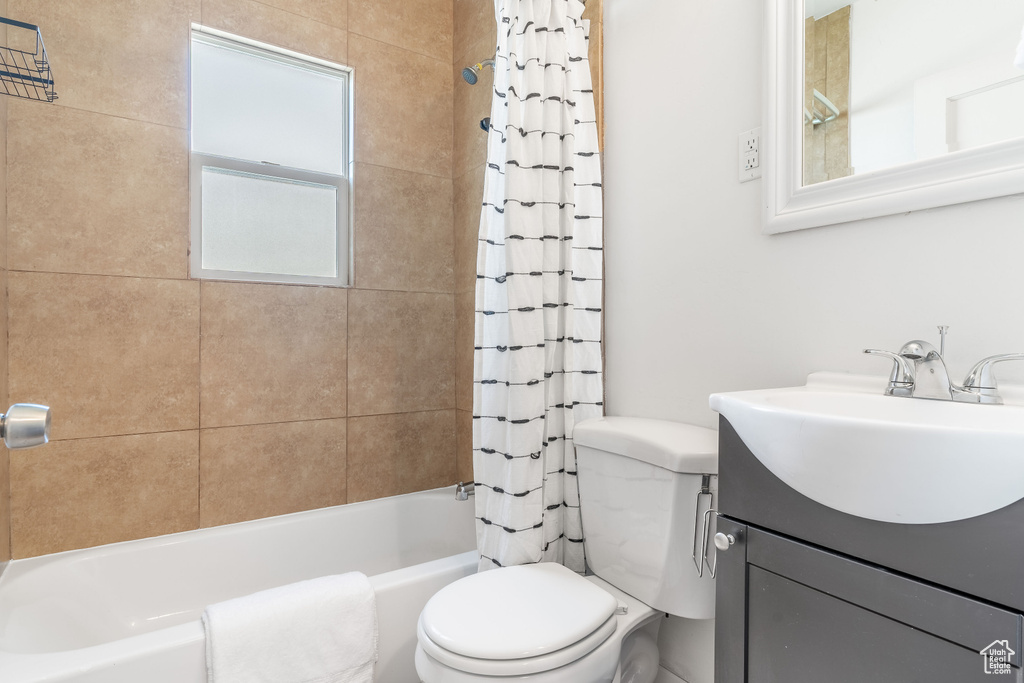 Full bath with toilet, shower / bath combination with curtain, and vanity