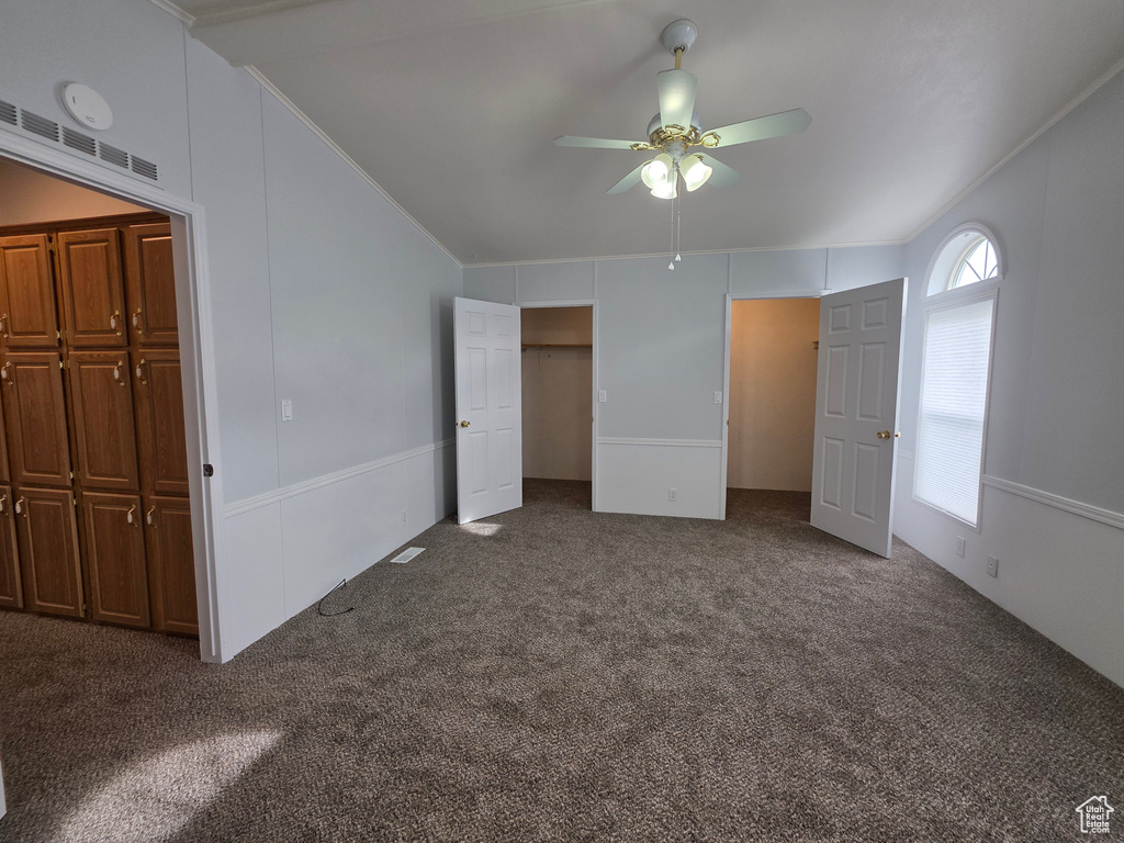 Unfurnished bedroom featuring carpet flooring, crown molding, and a ceiling fan