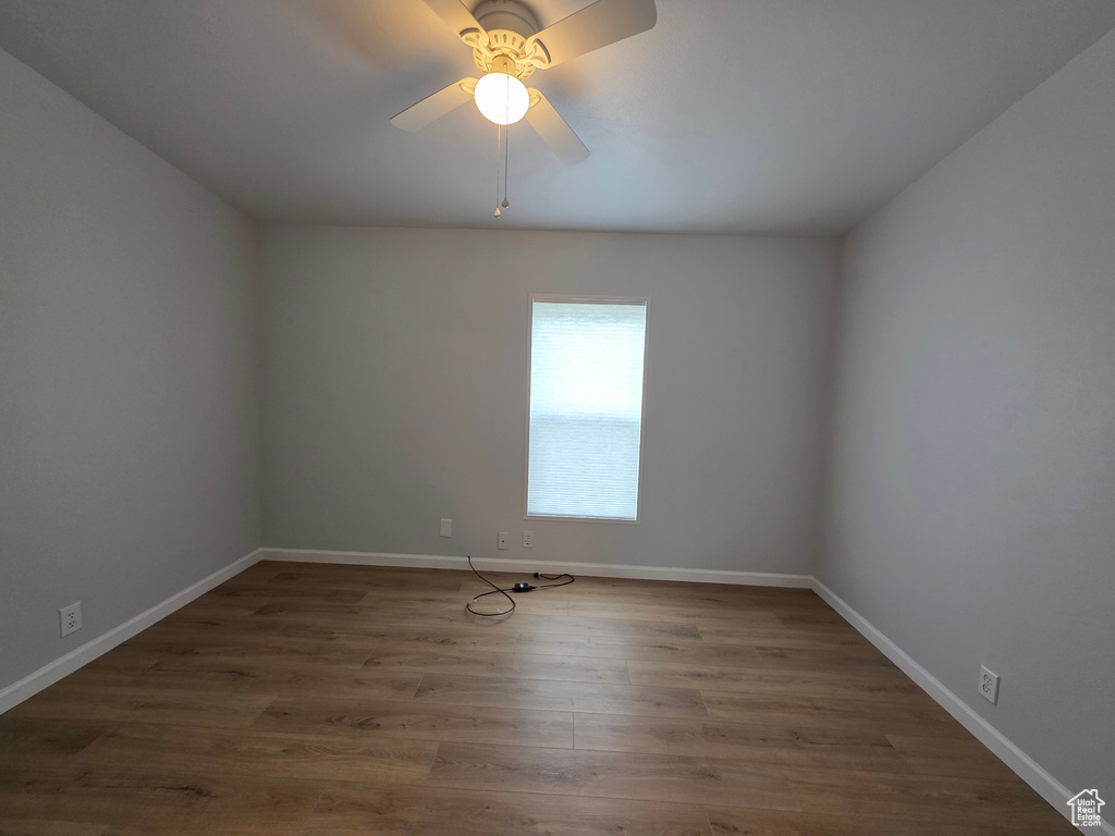 Spare room with wood finished floors, ceiling fan, and baseboards
