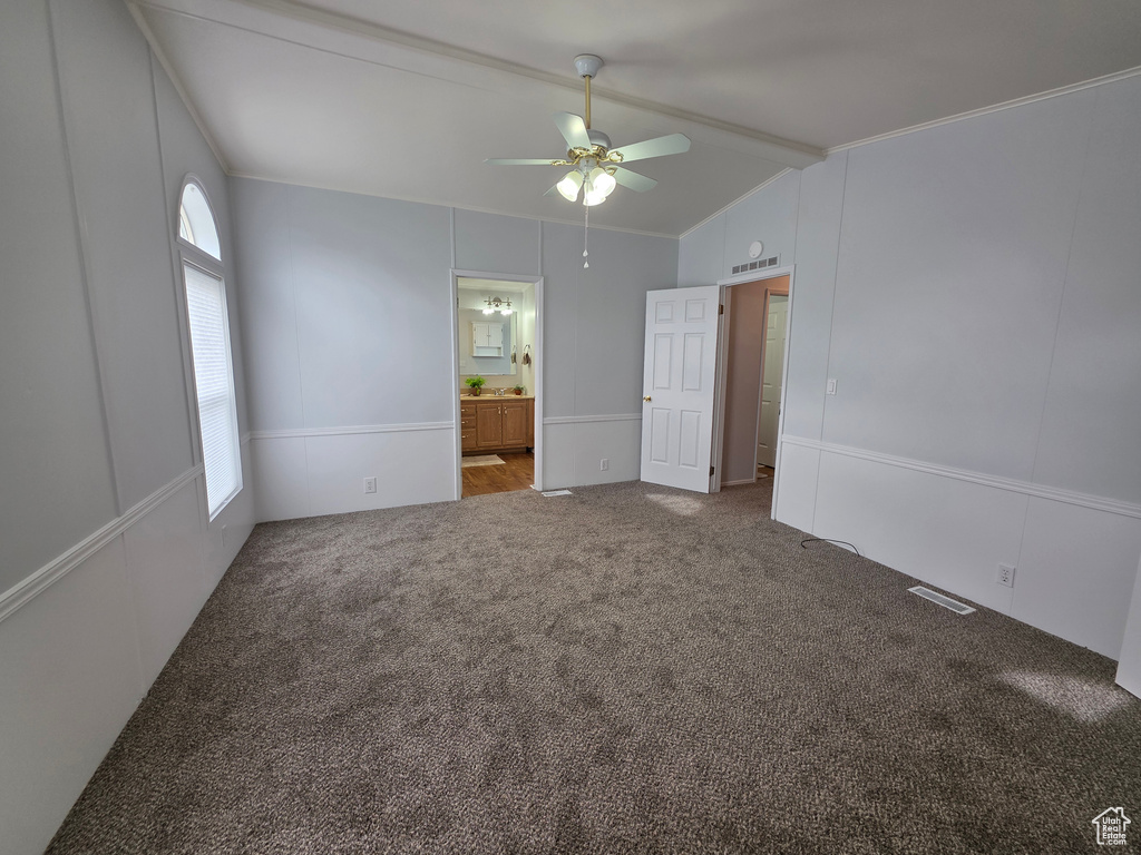 Unfurnished bedroom featuring carpet flooring, ensuite bath, and a ceiling fan