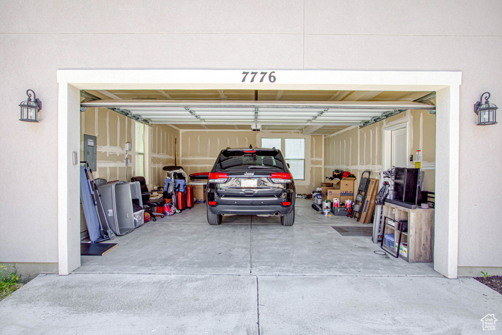 Garage with electric panel and driveway