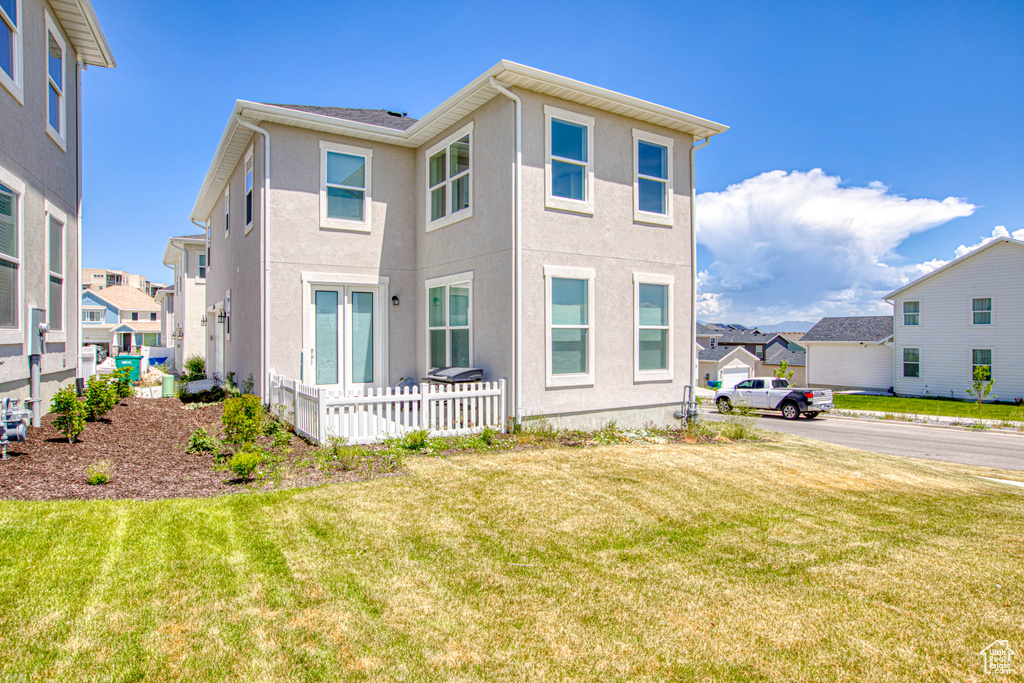 View of front facade with a residential view, stucco siding, and a front lawn