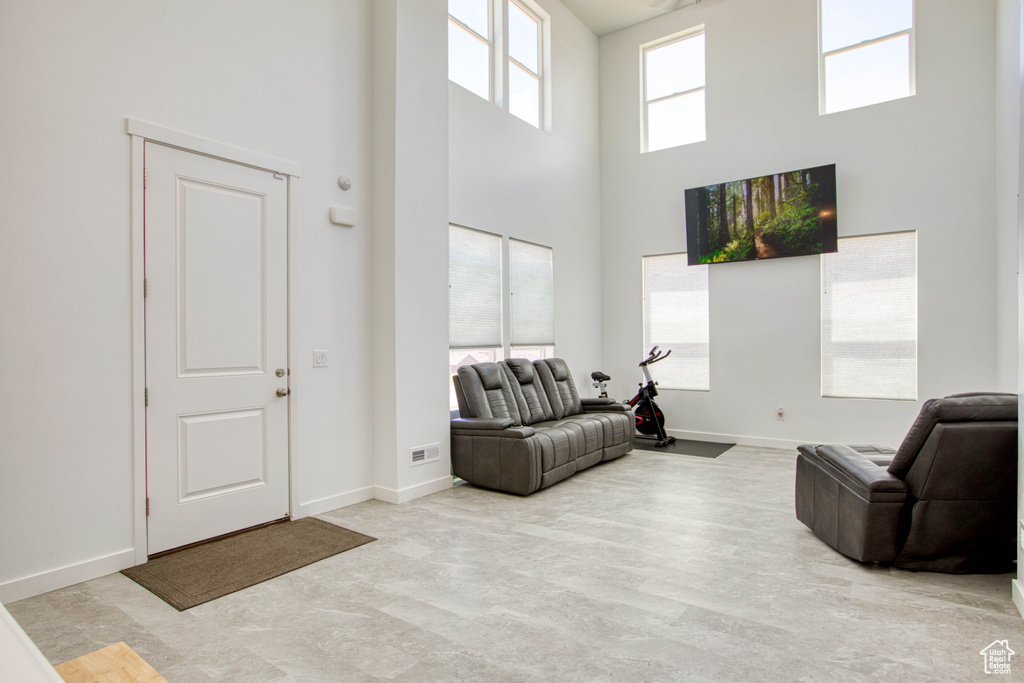 Living room featuring a towering ceiling and baseboards