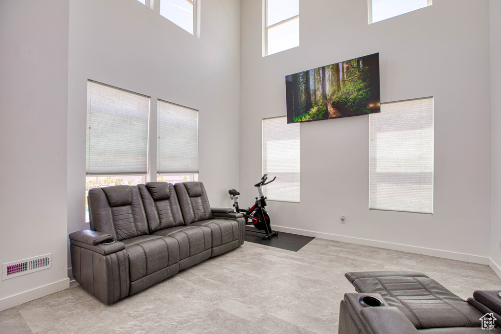 Living area featuring a high ceiling and baseboards