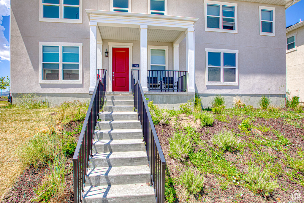Property entrance with stucco siding and a porch