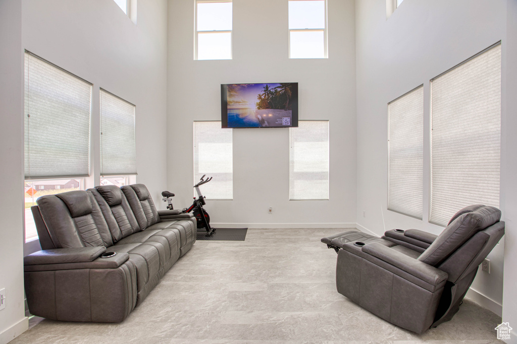 Living area featuring a towering ceiling and baseboards