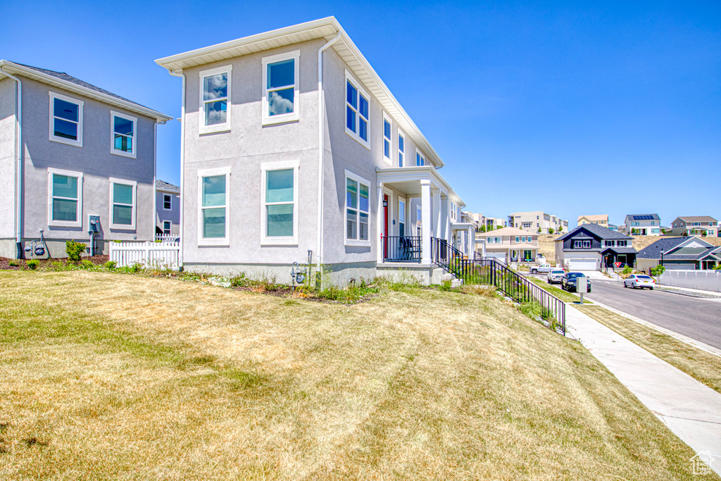 View of side of home featuring a residential view, stucco siding, and a porch