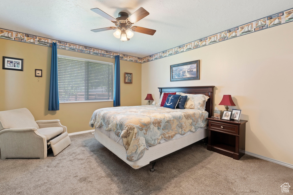 Bedroom featuring carpet floors, baseboards, ceiling fan, and a textured ceiling
