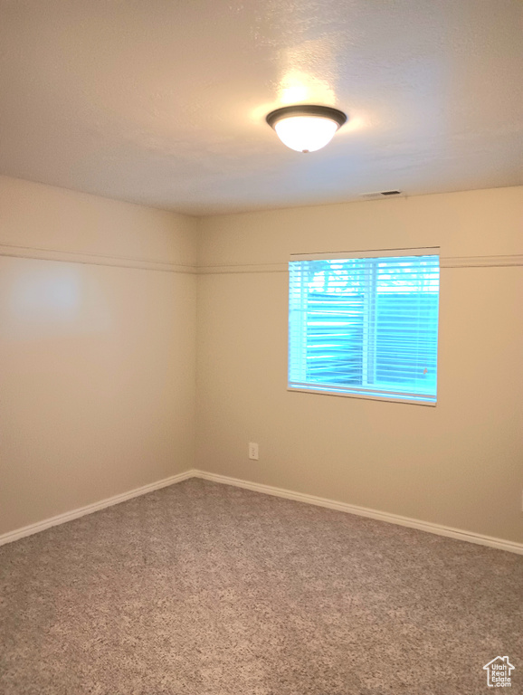 Carpeted empty room featuring baseboards