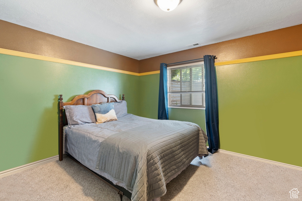 Carpeted bedroom featuring baseboards