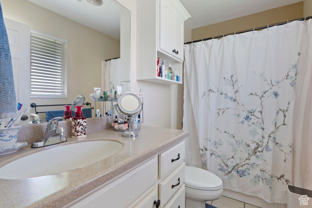 Full bathroom featuring vanity, toilet, tile patterned flooring, and curtained shower